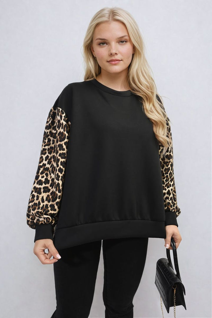 Woman in black shirt holding a leopard print long sleeve knitted jumper, showcasing its trendy design suitable for stylish, cozy wear.