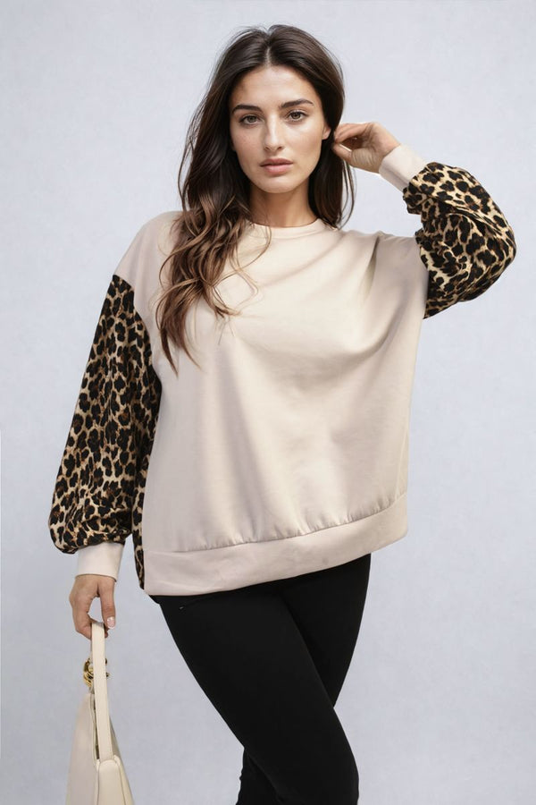 Woman holds a Leopard Print Long Sleeve Knitted Jumper, showcasing its cozy design and trendy leopard pattern, ideal for stylish warmth on chilly days.