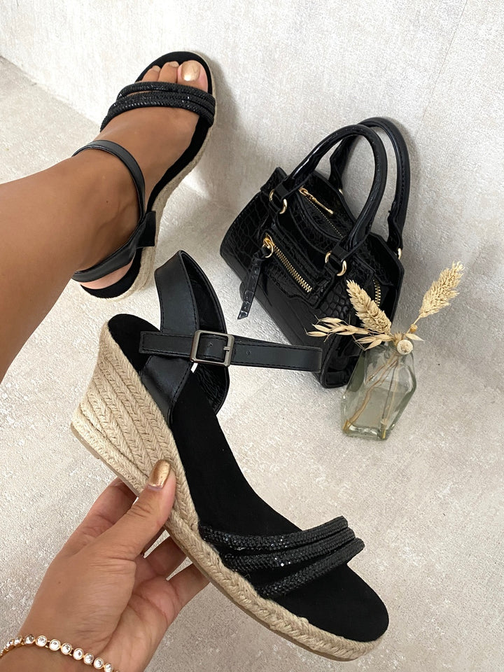 Strappy Wedge Heel Sandals showcased with a hand holding them, highlighting their elegant design and comfort, perfect for stylish summer transitions.