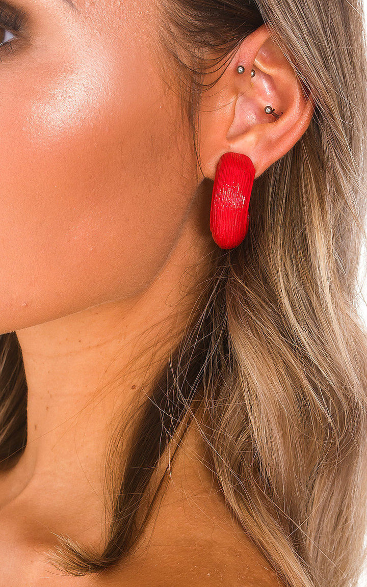 Statement Clip On Earrings displayed on a woman's ear, featuring a textured hoop design and clip-on fastening, ideal for adding a stylish touch to holiday outfits.