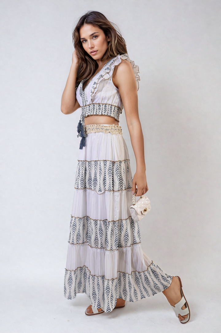 Woman in a V-Neck Boho Tassel Detail Crop Top, holding a white purse, showcasing a chic and breezy look ideal for holiday wear.