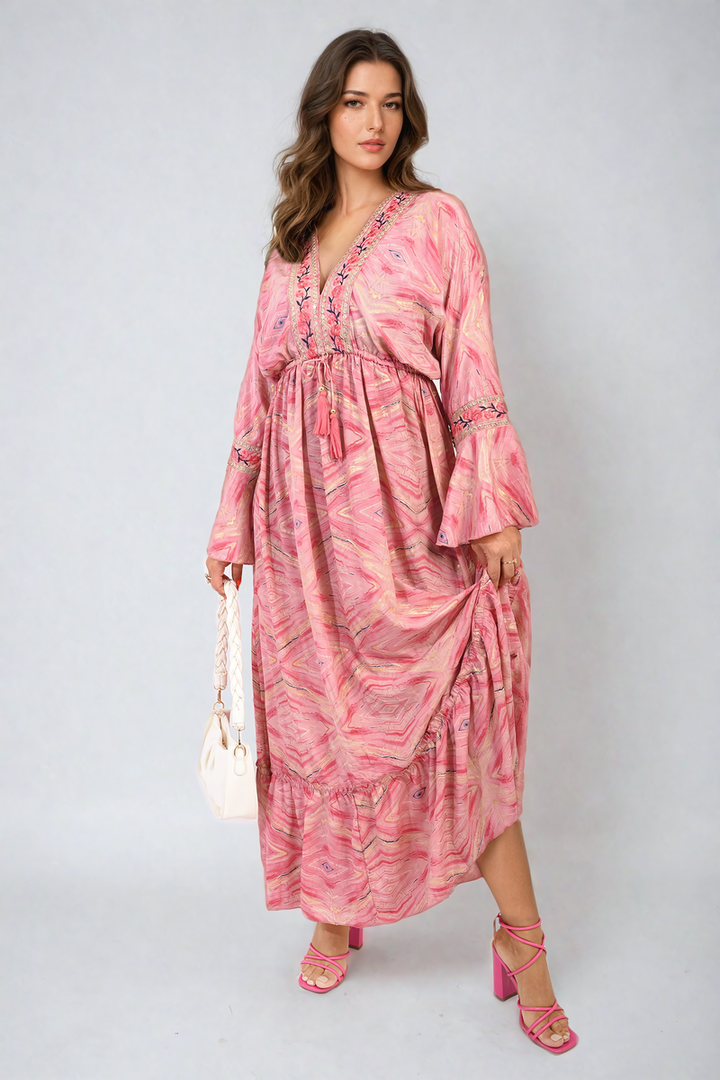 Woman wearing the Printed Long V-Neck Ruffled Hem Maxi Dress with Front Tassel Detail, showcasing its elegant design and flattering fit.