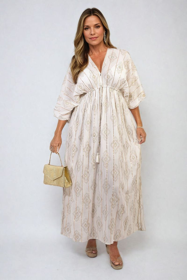 Printed V Neck Maxi Dress With Tassel Detail shown worn by a woman, highlighting the dress's flowing maxi length and elegant tassel waist tie.