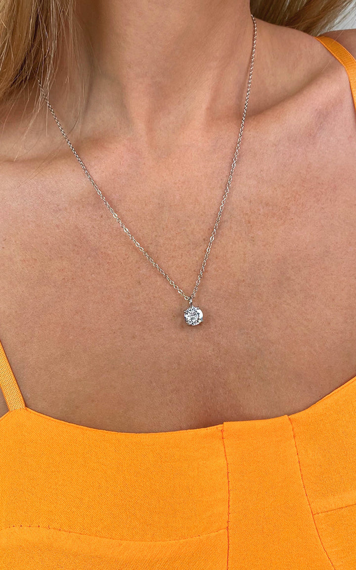 Woman wearing the Miah Diamante Solitaire Necklace, featuring a solitaire diamond pendant on a delicate chain, highlighting its elegance and sparkle.