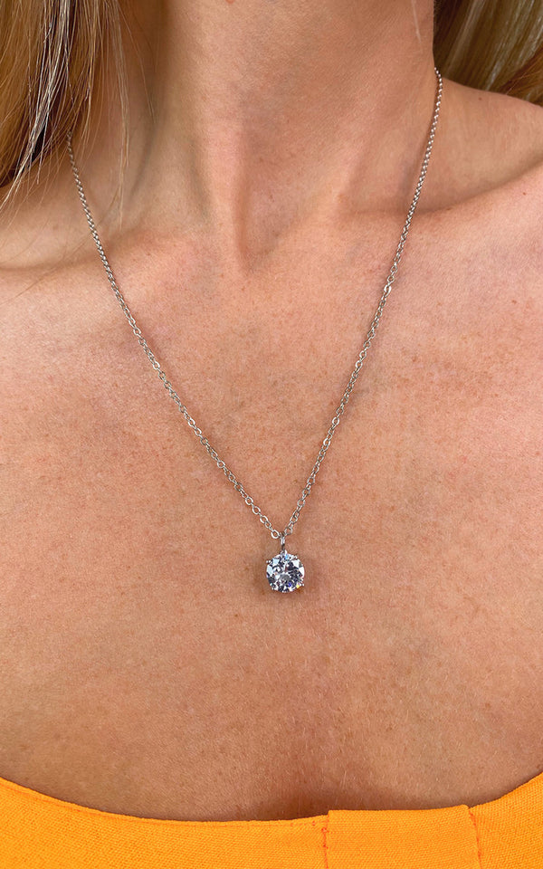 Diamante Solitaire Necklace worn by a woman, showcasing a single diamond pendant on a delicate chain, perfect for adding sparkle to any outfit.