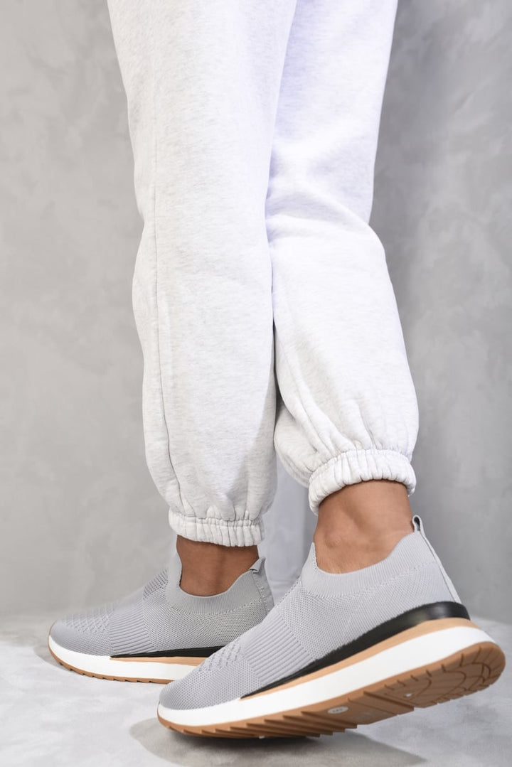 Mikayla Summer Sock Trainers in sleek design, worn indoors. Ideal for warm weather, offering comfort with a snug fit and easy slip-on style.