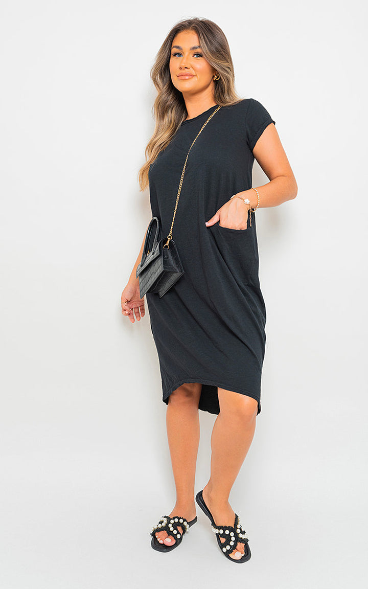 Woman wearing the Front Pockets Short Sleeve Midi Dress, showcasing its midi length and short sleeves, paired with sandals and a purse.