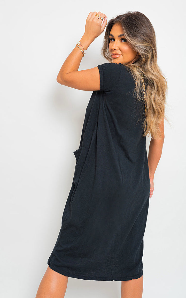 Woman wearing the Front Pockets Short Sleeve Midi Dress, showcasing its elegant midi length and convenient front pockets, perfect for versatile occasions.