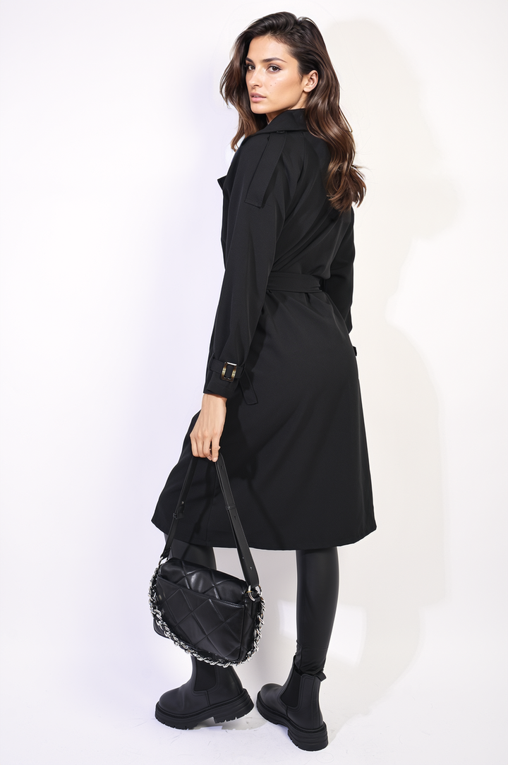 Woman models the Waist Tie Button Detailed Trench Coat, showcasing its chic button accents and waist tie for a sophisticated silhouette, ideal for versatile styling.