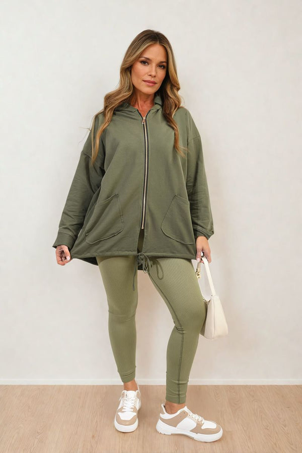 Woman wearing the Zip-Up Hooded Jacket with Pockets, posing indoors, highlighting the jacket's casual style and practicality for everyday wear.