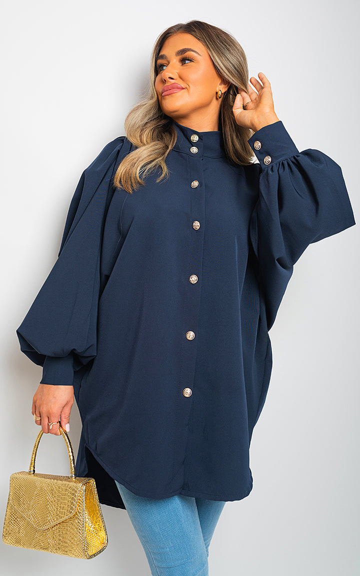 Oversized High Neck Shirt showcased by a woman, paired with a gold handbag, highlighting its relaxed fit and stylish design from Holiday Clothes UK.