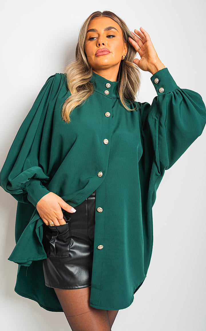 Woman wearing an oversized high-neck shirt with a relaxed fit, showcasing its casual elegance and versatility. Perfect for pairing with various outfits.