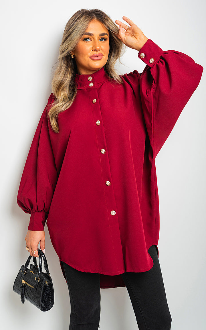 Oversized High Neck Shirt showcased by a woman, complemented with a black purse and black pants, exemplifying casual elegance and versatile styling for everyday wear.