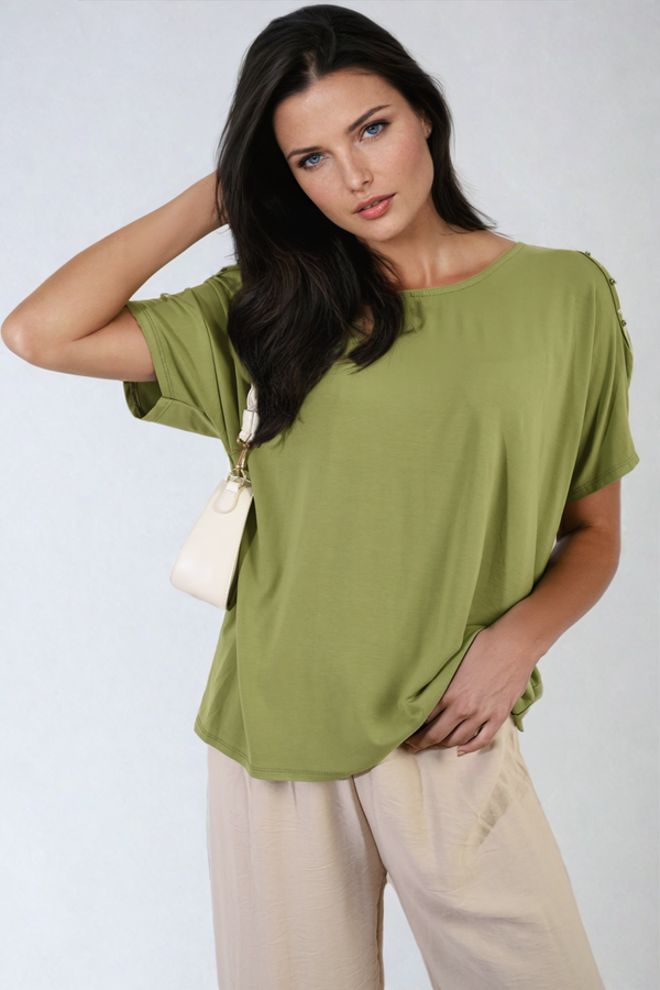 Woman showcasing the Pearl Cold Shoulder Top with elegant pearl accents, highlighting its stylish cutout design, ideal for both casual and sophisticated occasions.