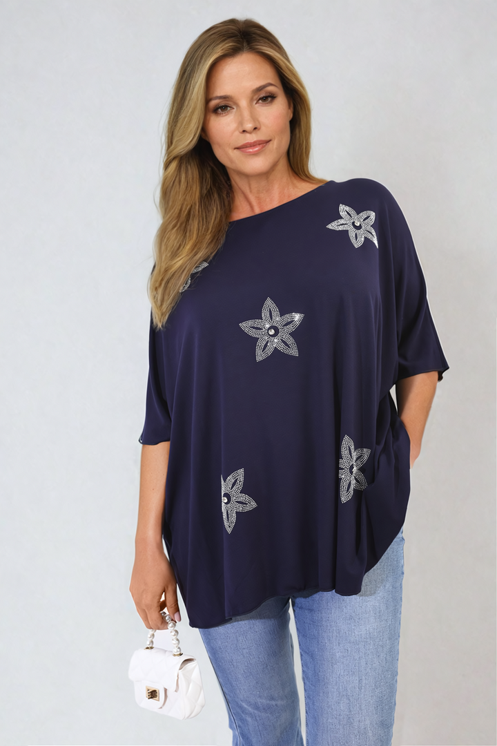 Woman wearing Nadia Floral Print Oversized Top with silver floral design, showcasing a relaxed and stylish look, perfect for casual and holiday wear.