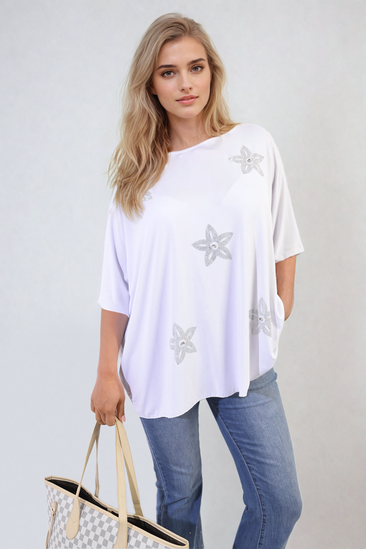 Woman holding the Nadia Floral Print Oversized Top, showcasing its relaxed, stylish floral design, perfect for casual wear from Holiday Clothes UK.