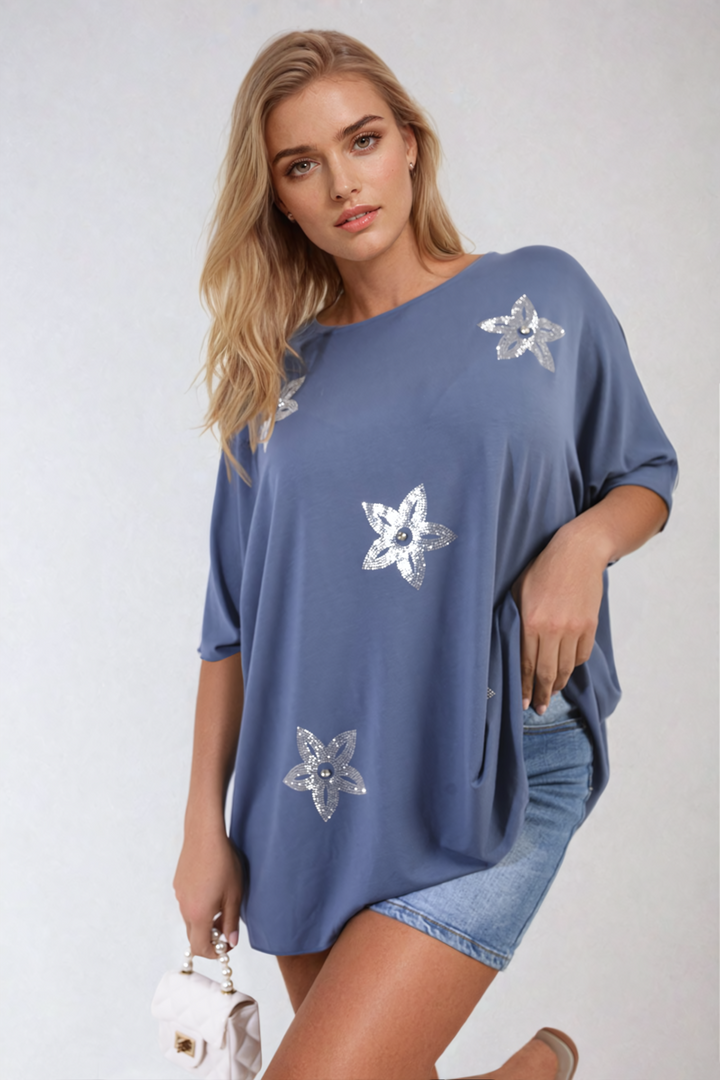 Woman wearing a Nadia Floral Print Oversized Top, featuring silver floral patterns and a relaxed fit, perfect for casual and stylish everyday wear.