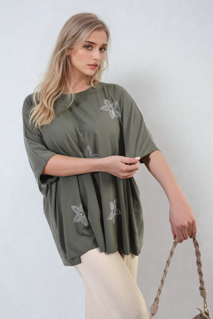 Woman holding a Nadia Floral Print Oversized Top, showcasing its relaxed fit and vibrant floral pattern, ideal for casual, stylish everyday wear.