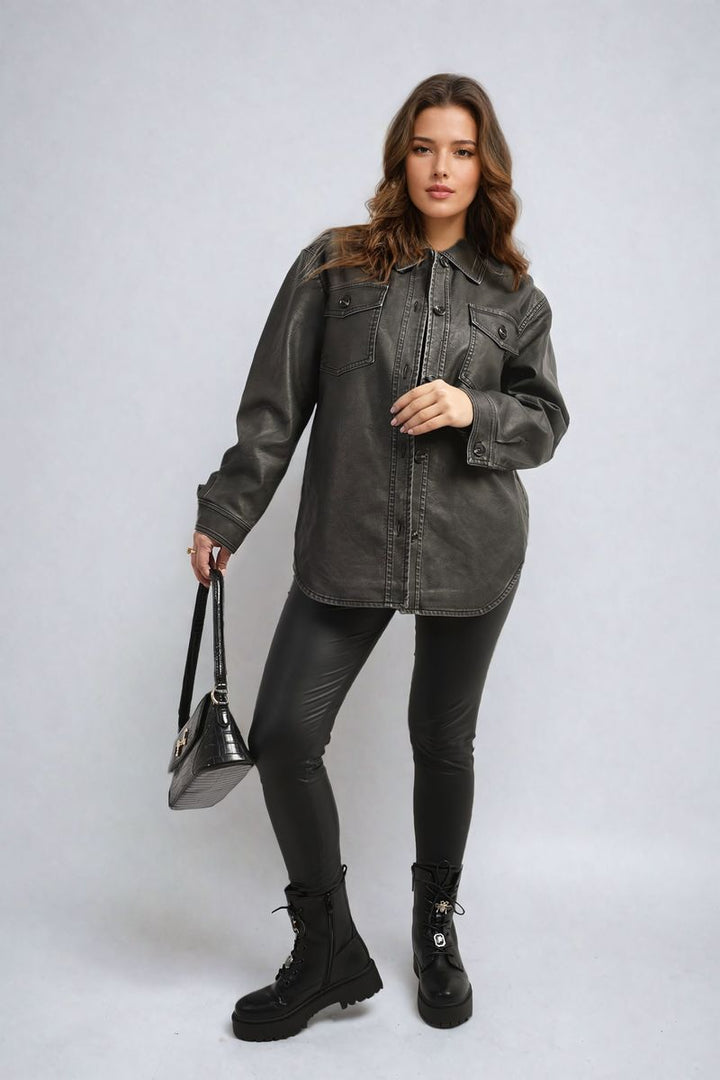 Woman wearing the Button Front Pocket Detail Faux Leather Jacket, holding a black purse. The jacket features a button-up design and practical pockets, ideal for casual outings.