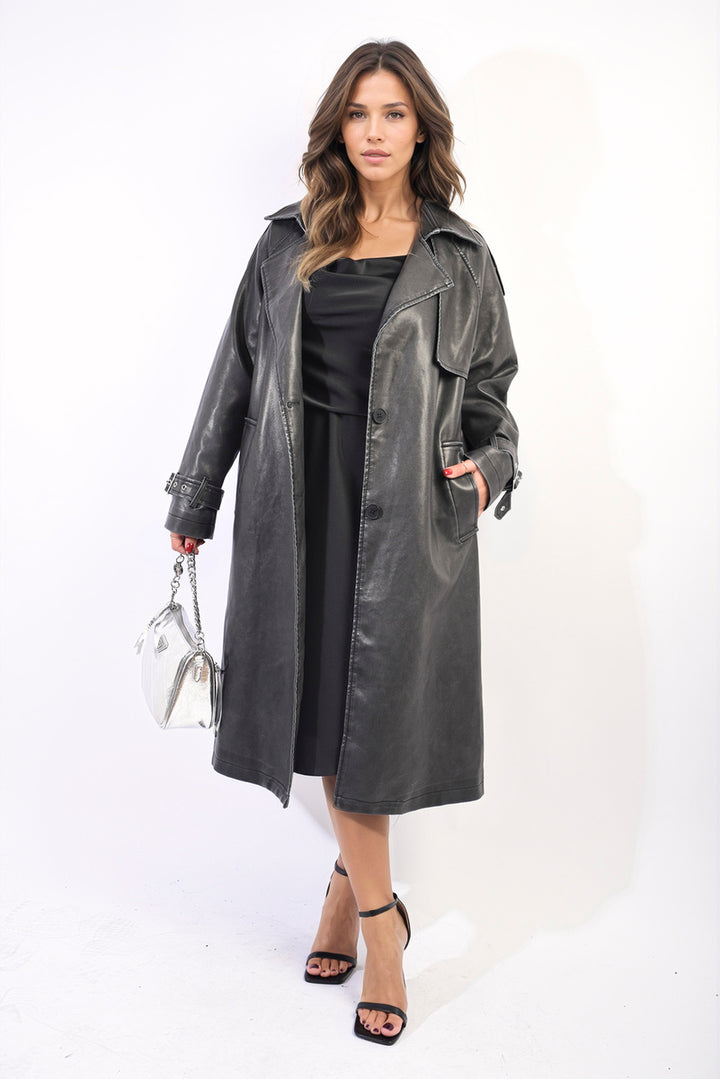 Woman in a black faux leather Lapel Neck Belted Trench Coat Jacket, showcasing its elegant design and adjustable belted waist for chic transitional weather styling.