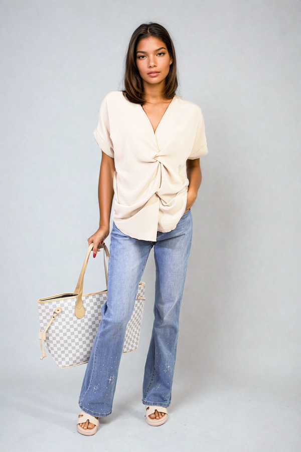 Woman holding V-Neck Twist Front Top, showcasing its elegant twist design and sophisticated V-neckline, exemplifying stylish yet casual holiday wear from Holiday Clothes UK.