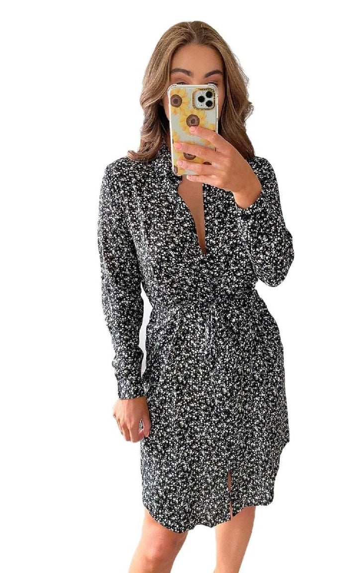 Woman in a loose-fitting Printed Mini Dress, taking a selfie. The dress features a V-neck and all-over print, perfect for summer styling.