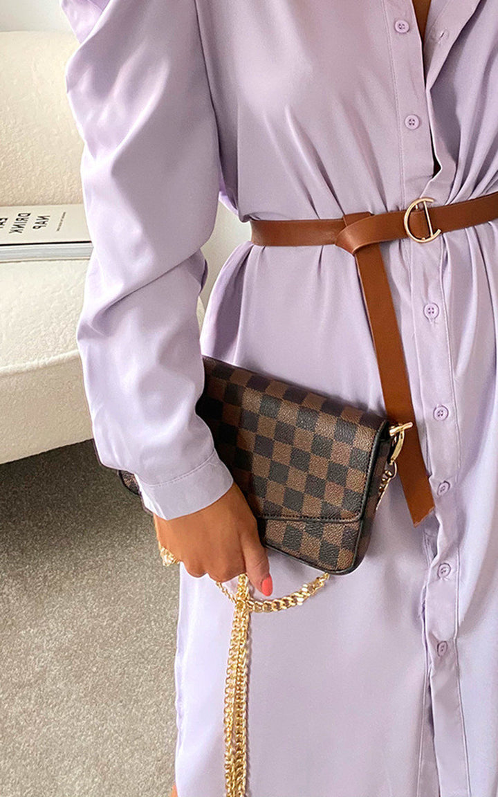 Person holding Check Print Clutch Bag with gold chain and button fastening, styled with a purple dress and brown belt.