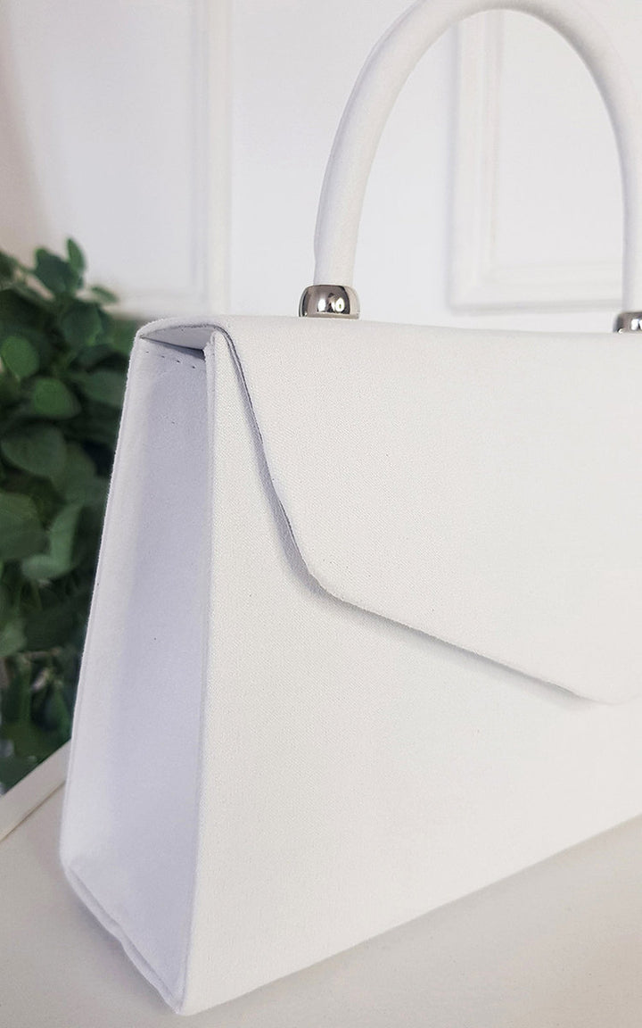 White Envelope Handbag with silver handles, featuring chic faux leather material, embodying trendy femininity and lightweight design for stylish versatility.