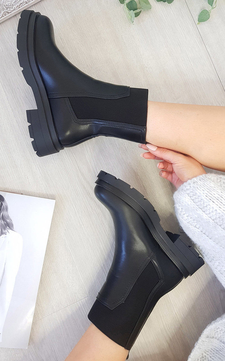 Chunky Ankle Boots styled with a black finish, perfect for pairing with various outfits. Ideal for fall and winter, providing warmth and style.