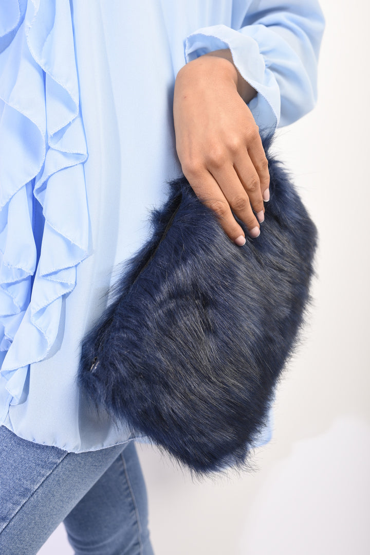 A hand holds the Faux Fur Shoulder Bag, showcasing its fluffy texture and detachable silver chain strap, perfect for pairing with casual outfits.