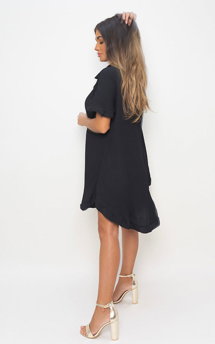 Woman modeling the Button Down Oversized Ruffle Short Sleeve Mini Dress, showcasing its ruffle sleeves and button-down design, paired with high heels.