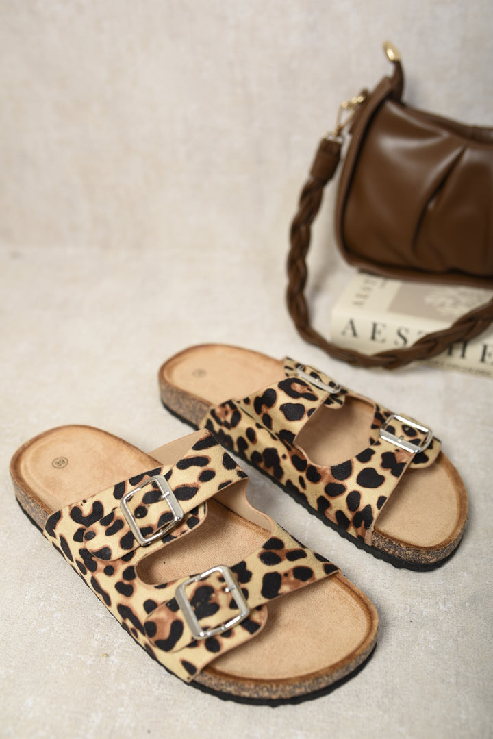 Leopard print Double Strap Sandals paired with a purse, highlighting the sandal's chic double strap design and sturdy sole for stylish summer wear.