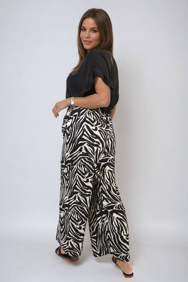 Woman wearing Zebra-Striped Print Wide Leg Trousers with a high waist, showcasing a bold fashion statement perfect for casual or elevated everyday looks.