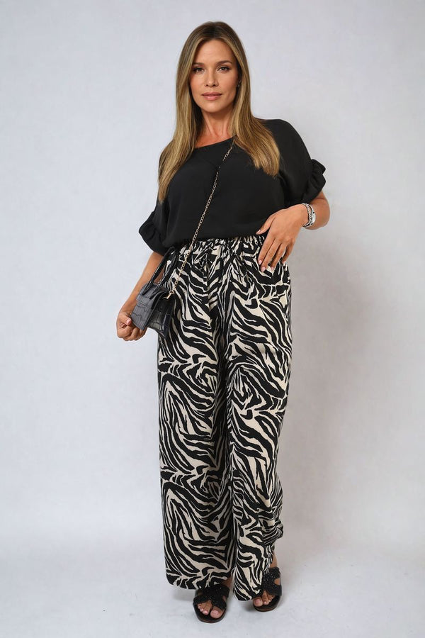 Zebra-Striped Print Wide Leg Trousers worn by a woman, showcasing a bold zebra pattern, perfect for stylish casual outings and statement-making fashion.