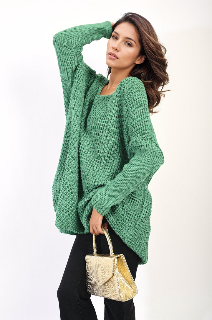 Woman in green sweater holding the Oversized Chunky Knitted Jumper, showcasing its cozy, relaxed fit, perfect for casual outings or at-home comfort.