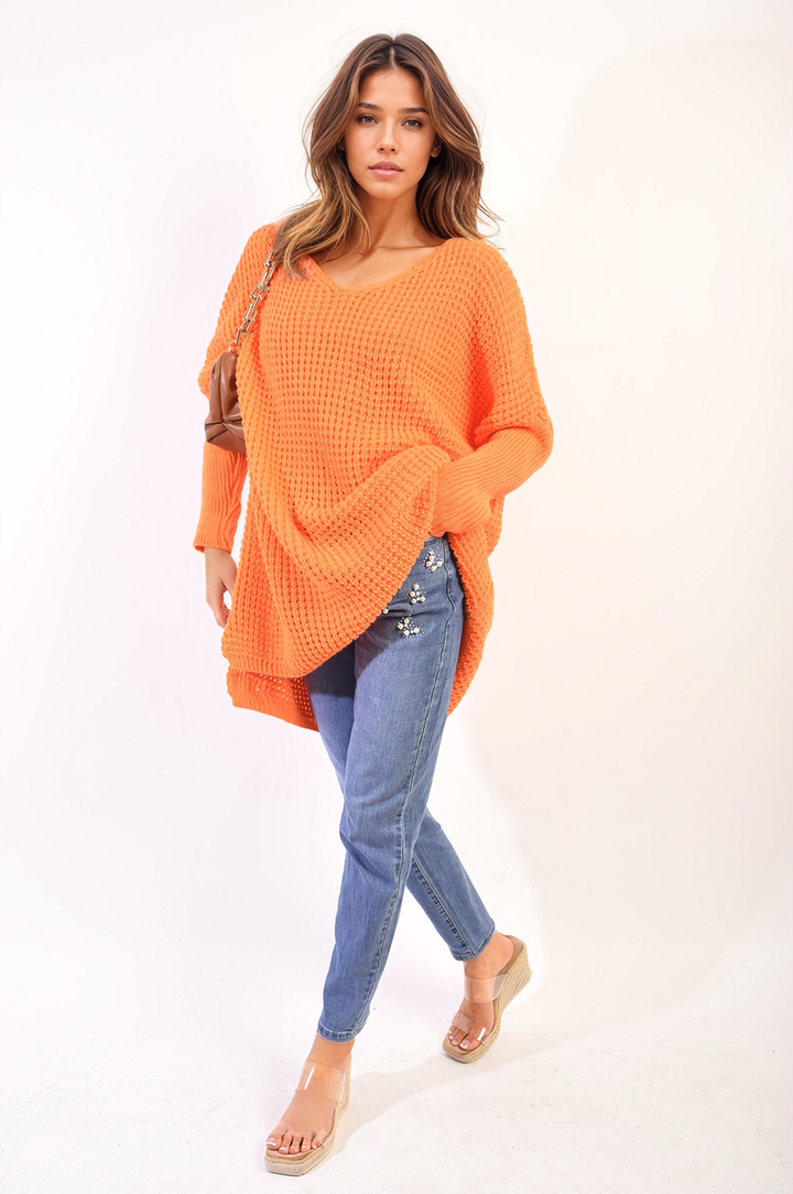 Woman modeling an oversized chunky knitted jumper paired with jeans, highlighting the cozy design of the Rebecca Jumper, perfect for casual or home settings.