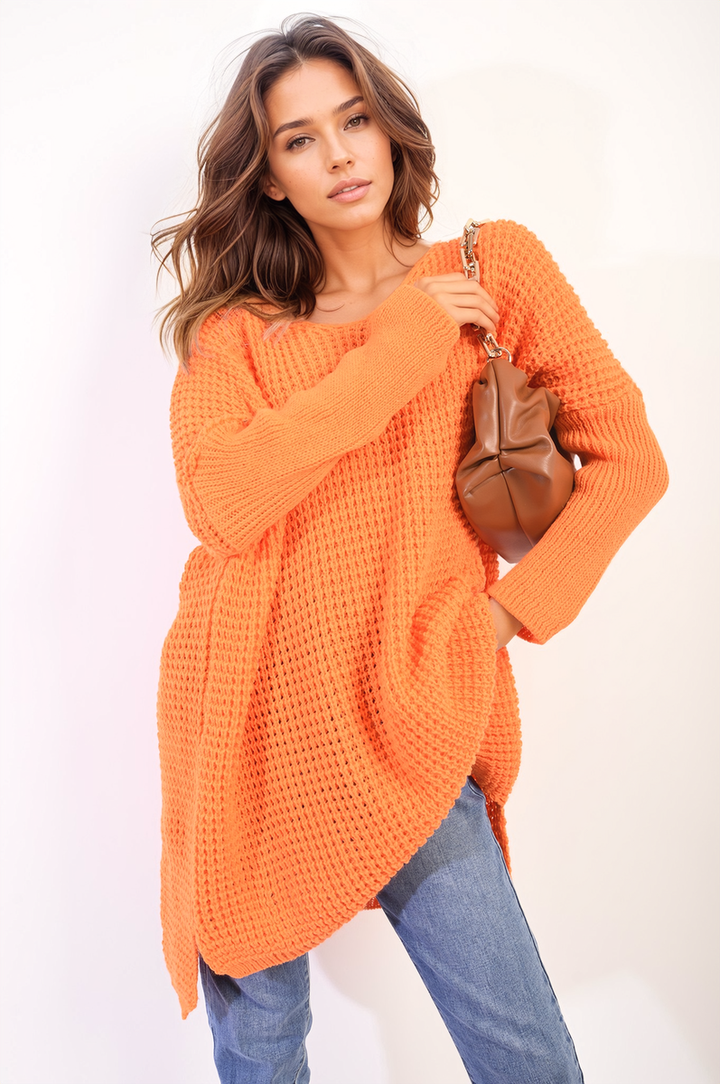 Woman in an oversized chunky knitted jumper holding a brown purse, showcasing cozy and stylish winter fashion from Holiday-clothes.co.uk.