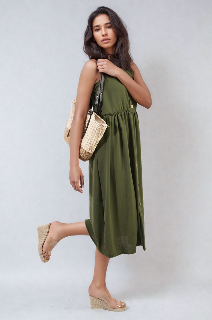 Button Front Strappy Midi Dress elegantly worn by a woman, styled with a woven straw bag, embodying summer fashion and versatile elegance.