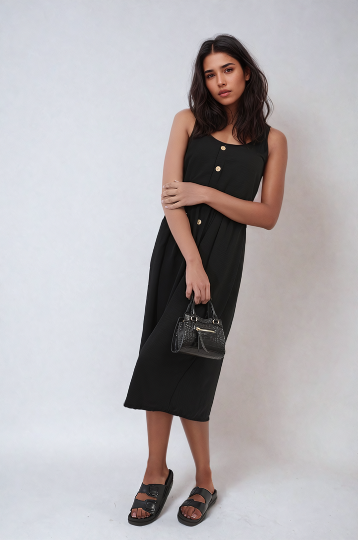 Woman in Button Front Strappy Midi Dress holding a purse, showcasing the dress's stylish strappy design and elegant button-front detail.