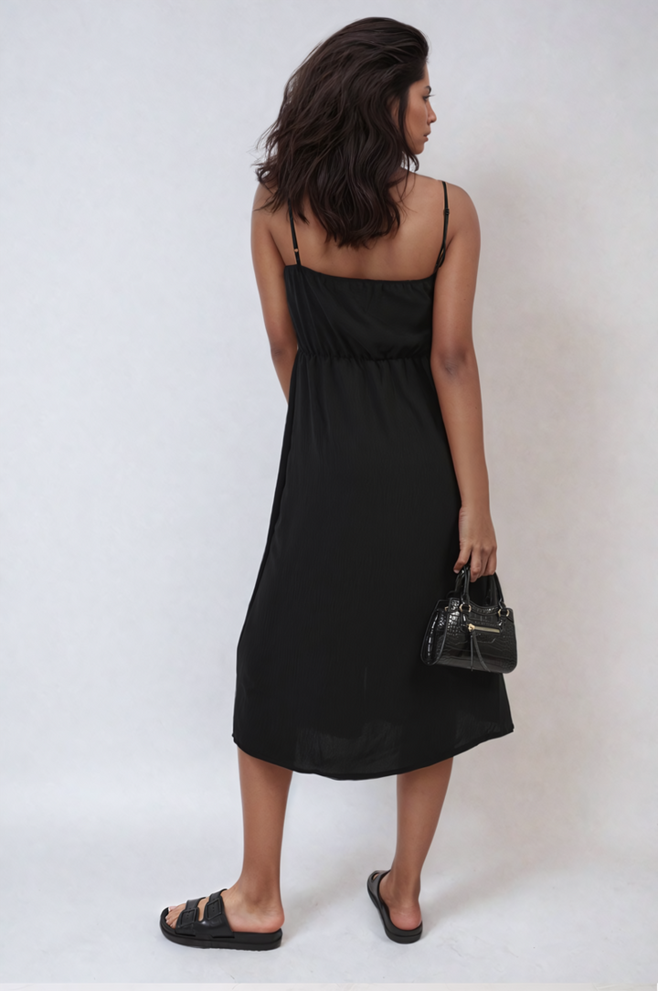 Woman in a Button Front Strappy Midi Dress holding a black purse, showcasing elegant summer style with strappy design and button-front detailing.