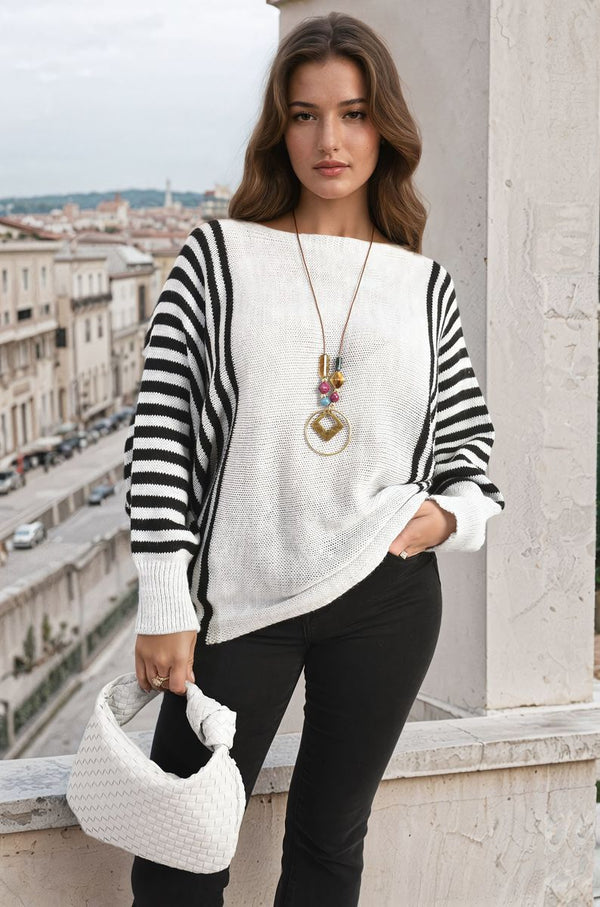 Woman in a striped batwing long sleeve knitted jumper, standing on a balcony, showcasing the cozy and stylish design, ideal for casual outings.