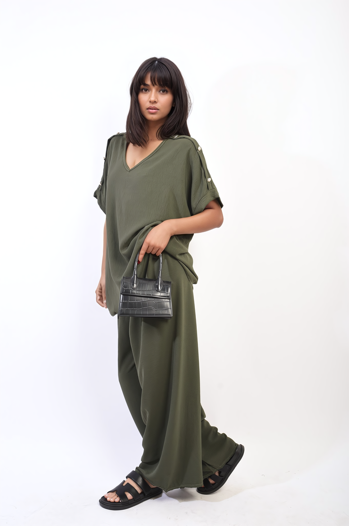 Woman wearing the Button Detail V Neck Loose Top and Wide Leg Trouser Co-ord Set, holding a black purse and showcasing black sandals.