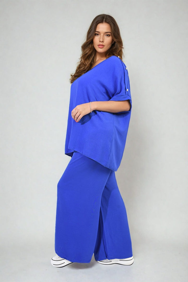 Woman wearing the Riley Button Detail V Neck Loose Top and Wide Leg Trouser Co-ord Set, showcasing a chic summer ensemble with elegant button accents.