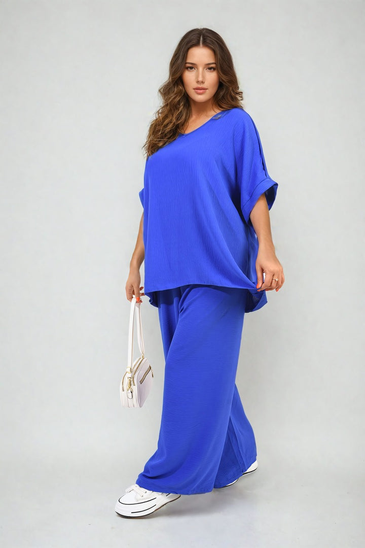 Woman in Button Detail V Neck Loose Top and Wide Leg Trouser Co-ord Set holding a white purse, showcasing chic summer fashion from Holiday Clothes UK.