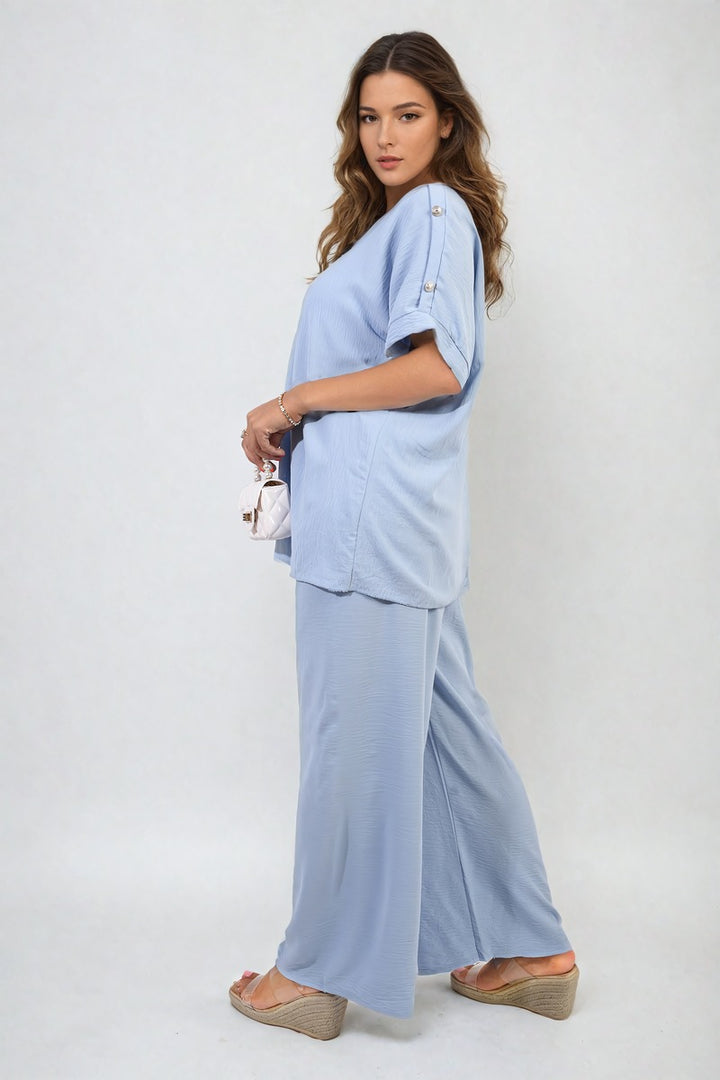 Woman wearing the Riley Button Detail V Neck Loose Top and Wide Leg Trouser Co-ord Set, showcasing its elegant, breezy design perfect for stylish summer outings.