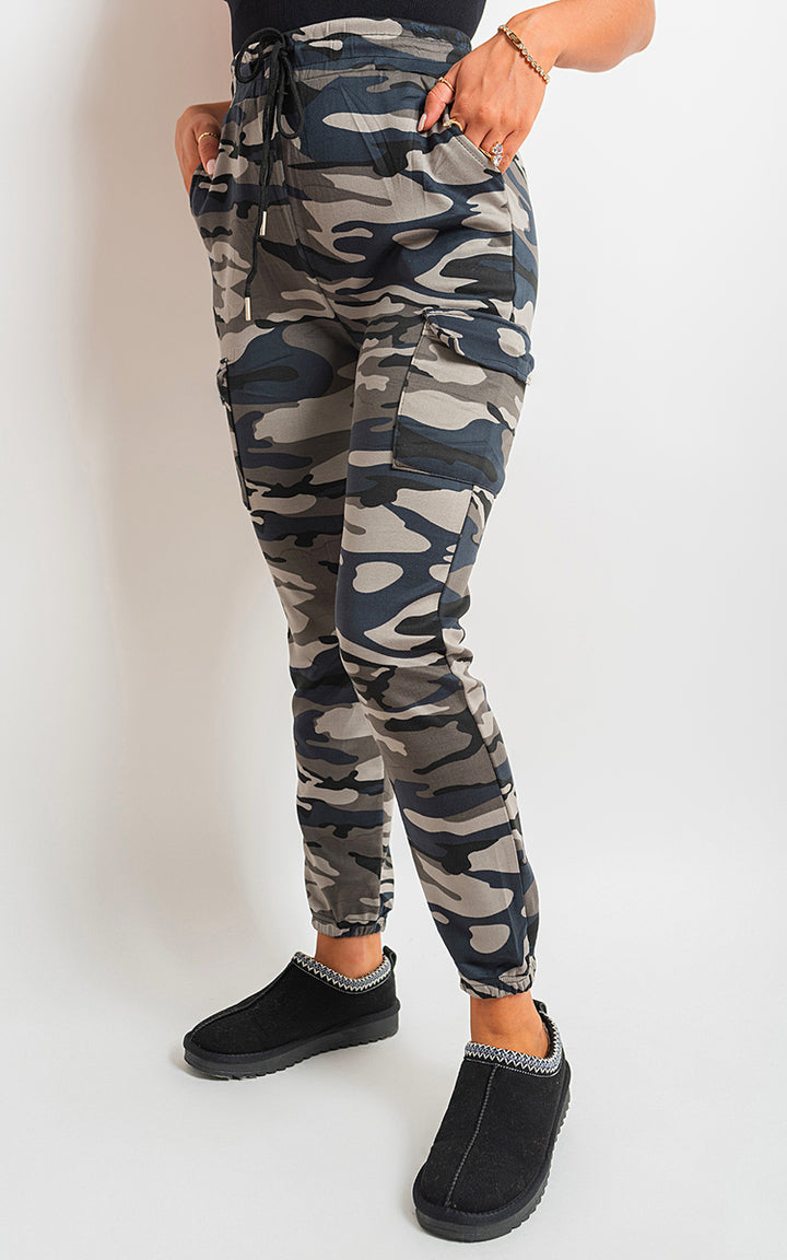 Robyn Camo Print Tie Cargo Trouser with adjustable waist, worn by a person, showcases functionality and style with multiple pockets and a camo pattern.