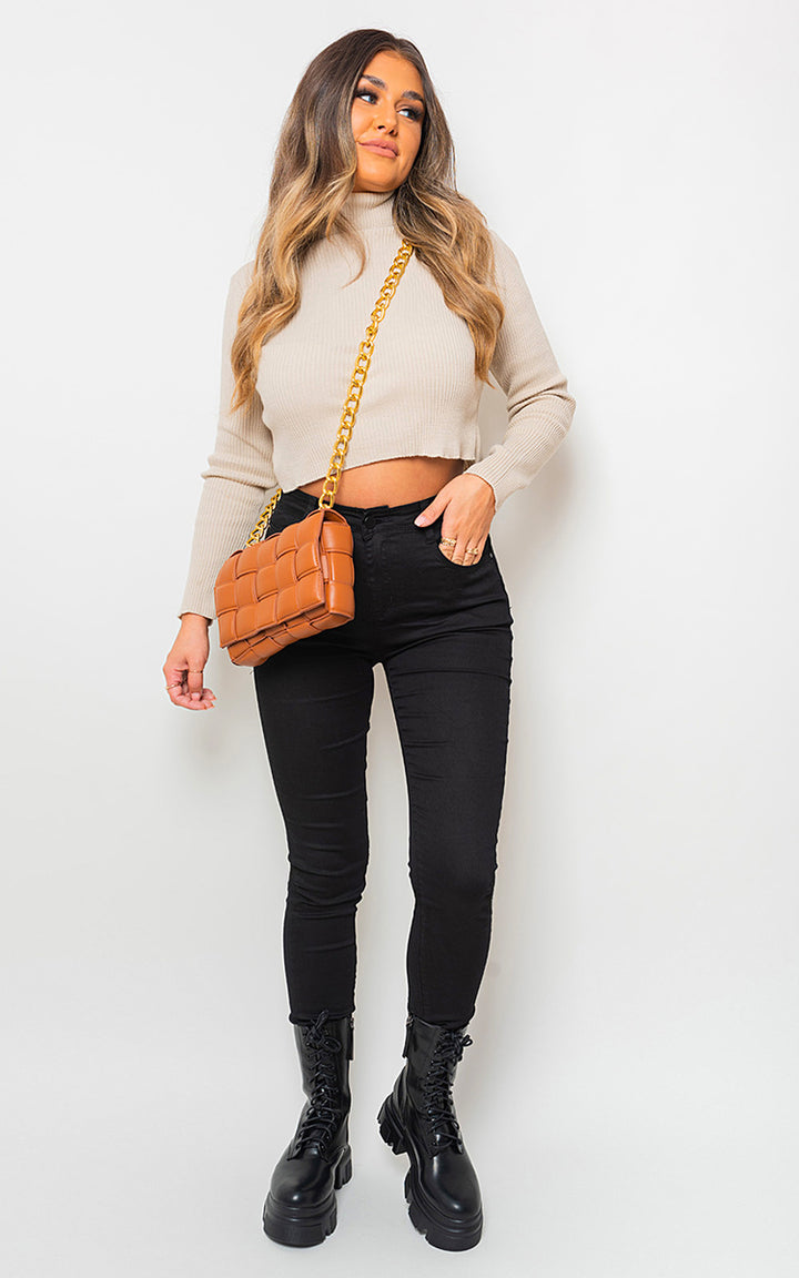 Woman wearing High Waisted Skinny Fit Jeans, styled with a tan sweater and black boots, showcasing a chic and flattering look.