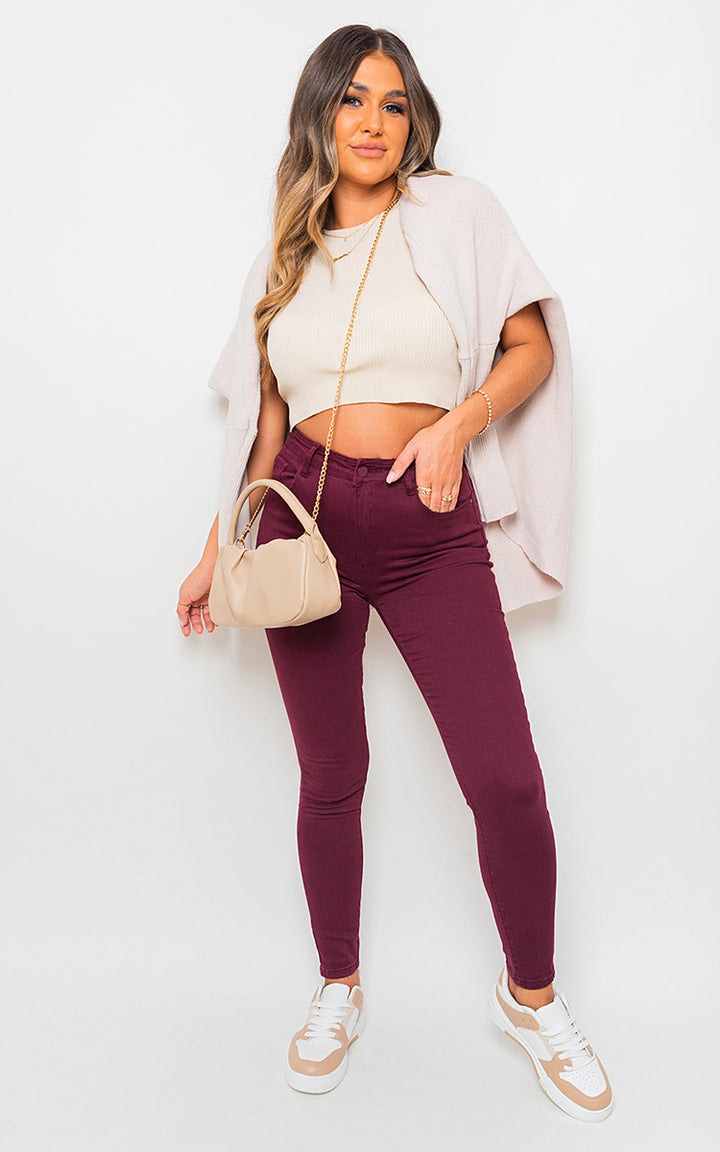 Woman wearing High Waisted Skinny Fit Jeans, white top, and accessories, showcasing trendy style and flattering fit from Holiday Clothes UK's collection.