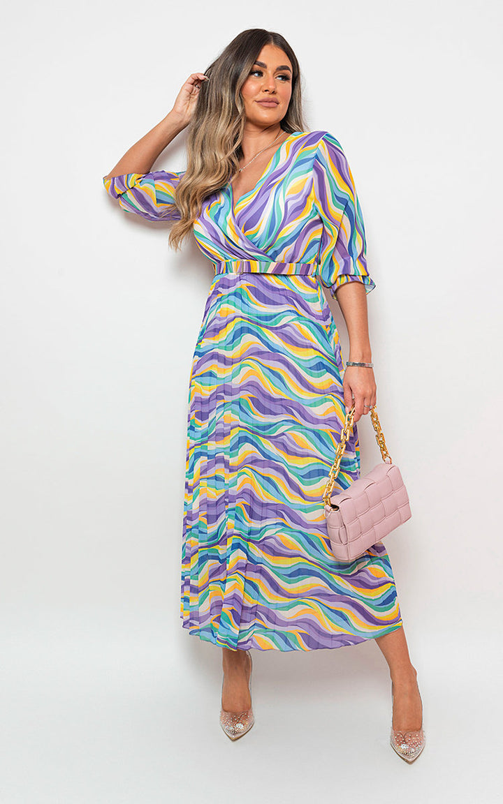 Woman wearing the Long Sleeve Printed Maxi Dress with Belt Detail, featuring a stylish print and flattering fit, holding a pink purse with gold chains.