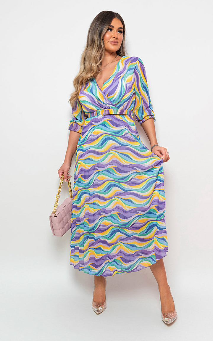 Woman modeling the Long Sleeve Printed Maxi Dress with Belt Detail, showcasing its elegant pattern and flattering silhouette, ideal for versatile holiday or everyday wear.